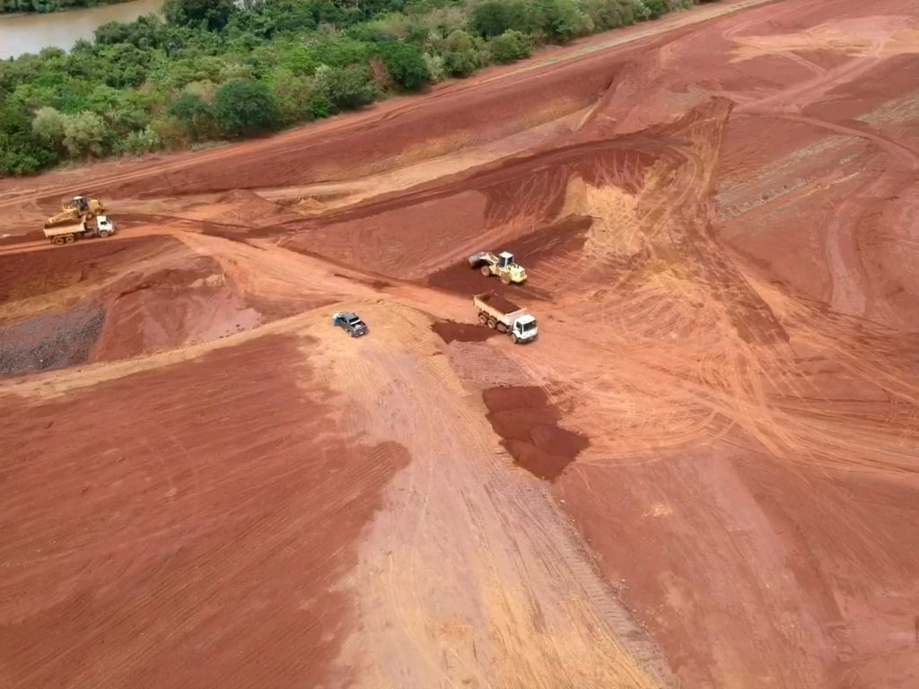 Movimentação de terra com caminhão e máquinas em obra de terraplenagem